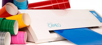 Image of a Silhouette Cameo die cutter surrounded by rolls of brightly colored vinyl