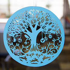 Image of a blue paper circle with a die cut tree in the center