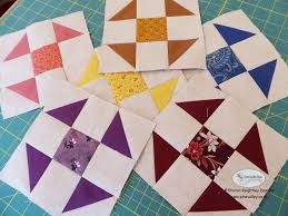 Colorful shoofly quilt blocks on a green background