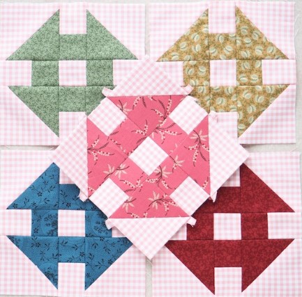 Image of five churn dash quilt blocks in green, yellow, red, blue, and pink