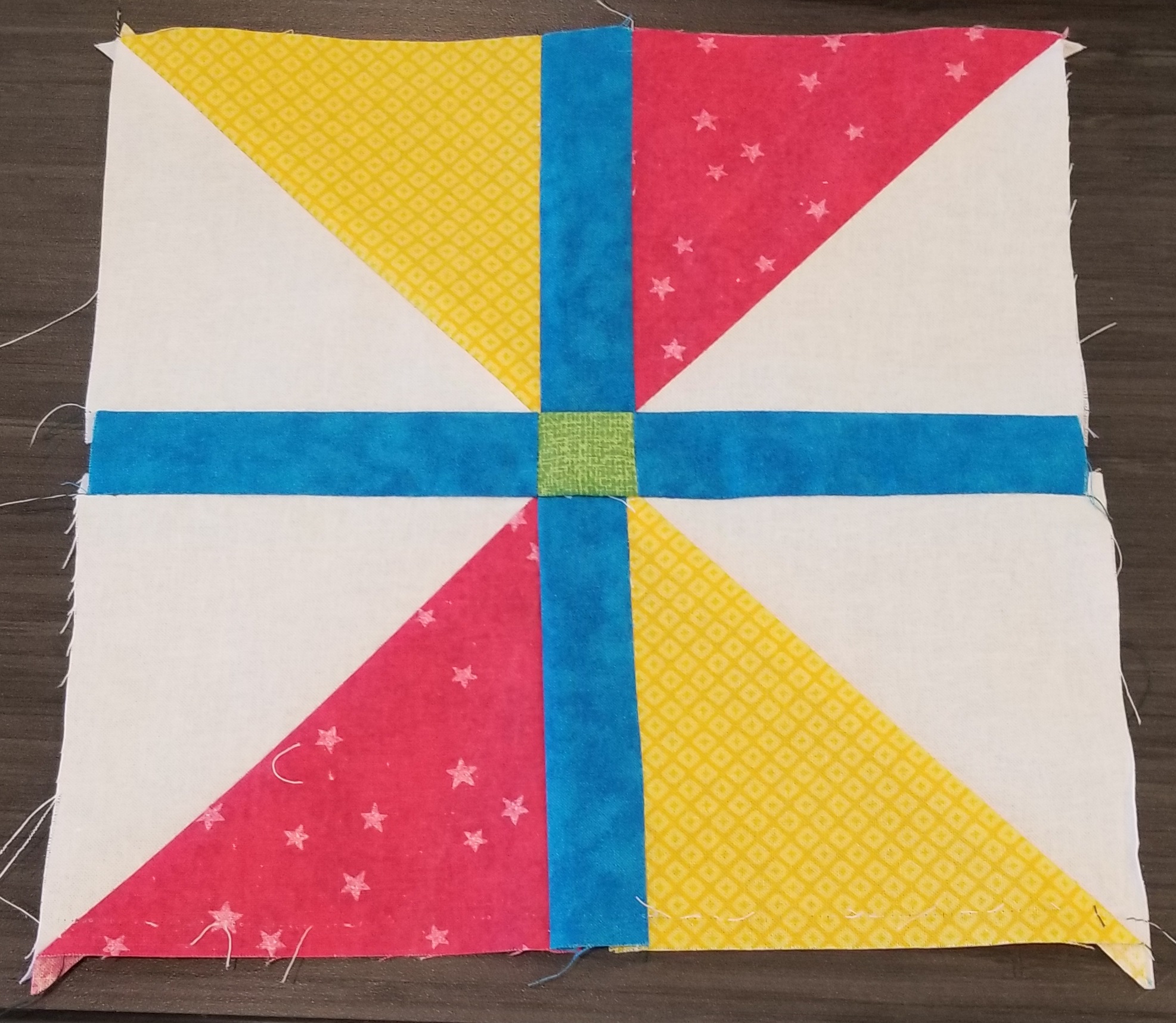 A windowpane quilt block in red, yellow, blue, white, and green