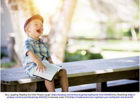 Child looking at book and laughing