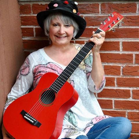 woman holding red guitar