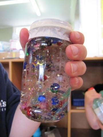 Hand holding calming glitter jar