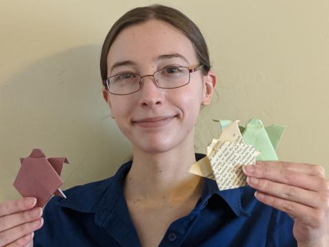 Picture of presenter holding up origami tortoises.