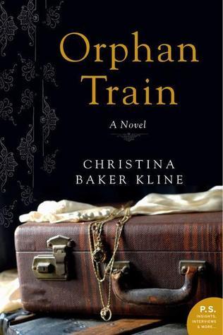 Cover of the book Orphan Train by Christina Baker Kline. The cover shows a solid black background with a brown suitcase in the foreground. It has a piece of fabric resting on top of it and a neckless on top of that.