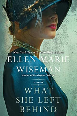 Cover of the book What She Left Behind by Ellen Marie Wiseman. It shows a closeup of a woman in a hat with a blue shirt and neckless slightly smiling at the camera.
