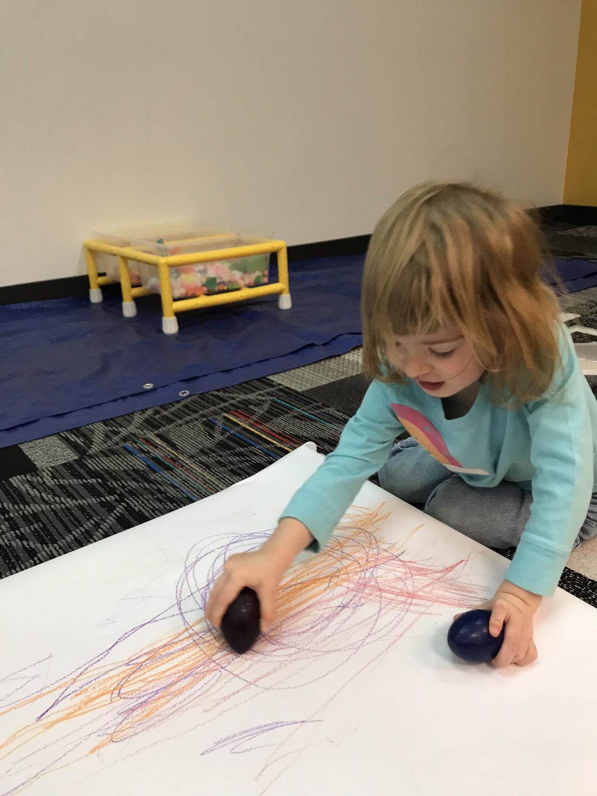 Toddler coloring with palm-grip crayons.